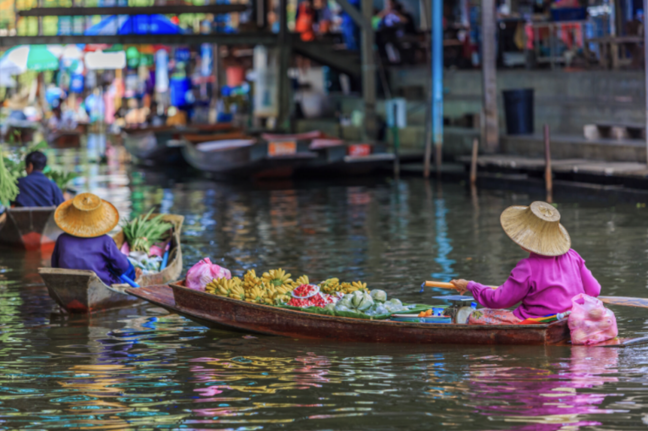 Boote mit verschiedenen Waren auf einem Fluss in Thailand